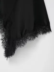 Close-up of elegant black satin dress featuring delicate lace hem and irregular cut.