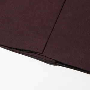 Macro view of high-quality burgundy blazer fabric showing stitching and texture