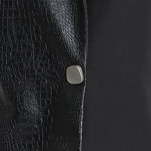 Macro view of black crocodile pattern PU leather and smooth fabric on a vest
