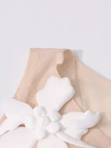 Λεπτομερές κοντινό πλάνο του 3D λευκού λουλουδιού σε διχτυωτό γυναικείο καλοκαιρινό τοπ
