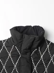 Close-up of black quilted vest featuring elegant silver rhinestone lattice pattern.