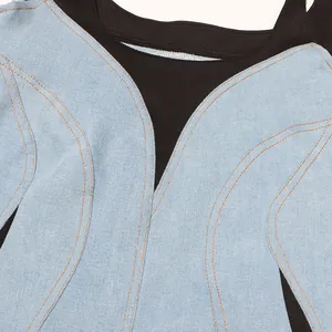 Primer plano detallado de vestido vaquero azul claro con costuras naranjas y paneles negros