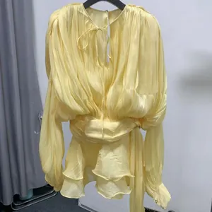 Detail view of yellow French style long-sleeve pleated mini dress with ruffles