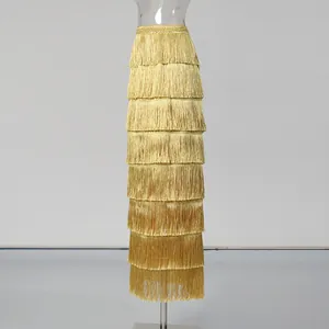 Detail view of an elegant golden tiered fringe maxi skirt showing multiple layers of tassels.