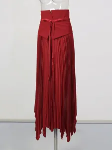 Detail view of high-waisted red pleated skirt with drawstring bow and irregular hem.