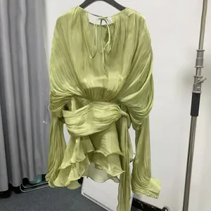 Close-up detail of a French style loose pleated ruffled mini dress in a vibrant lime green finish.