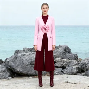 Detailed close-up of a pink blazer featuring a large 3D flower and elegant slim-waist design.