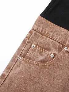 Close-up of brown denim texture and pocket detail with metal rivets on flare jeans
