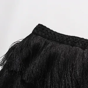 Detail shot of black fringe layers and decorative wavy trim on high waist skirt.