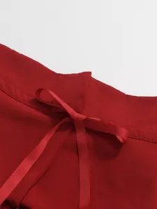 Detail view of a red French style elegant skirt featuring a high waist drawstring ribbon bow.