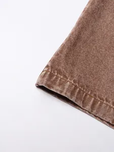 Close-up of brown denim micro-flare pants hem showing fine stitching and fabric texture.