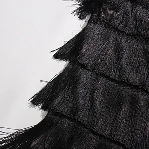Macro view showing the intricate black fringe and tassel layers of the tiered skirt.