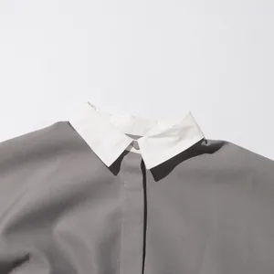Close-up van een Japanse vintage blouse met witte contrastkraag en grijze stof.