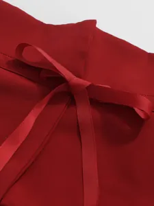 Detail of elegant red French style skirt showing a delicate ribbon bow at the waist