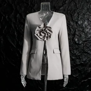 Detail view of a light grey blazer with a sophisticated 3D ruffled flower ornament