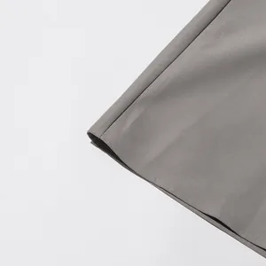 Detailopname van de fijne stiksels en textuur van de zoom van de grijze damesjas model
