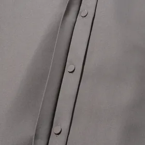 Detailopname van met grijs stof beklede knopen op een stijlvolle lange damesjas