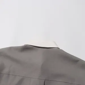 Detail van een retro Japanse losse lange jas met een witte contrastkraag en grijze stof