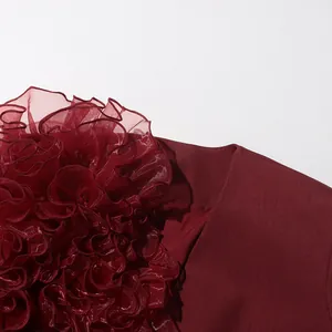 Close-up detail of the elegant burgundy blazer with three-dimensional ruffled mesh flower