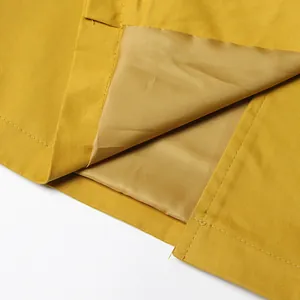 Close-up detail of high-quality lining and precise stitching on yellow trench coat