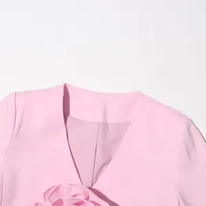 Close-up of elegant pink blazer featuring a sophisticated 3D floral detail at the neckline