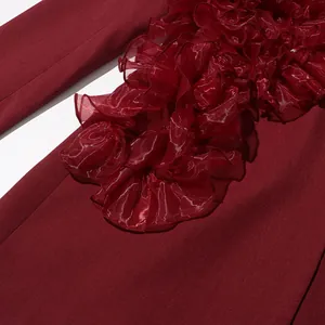 Close-up of elegant burgundy blazer with delicate mesh ruffle trim detail.