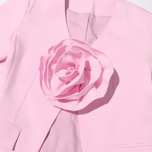 Close-up detail of oversized 3D fabric rose on an elegant pink blazer for women.
