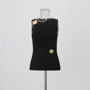 Detalle de top sin mangas negro de estilo francés con detalles metálicos.