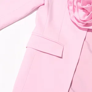 Detailed view of the delicate pink blazer's 3D flower applique and its pocket flap
