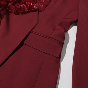 Close-up of burgundy blazer pocket and elegant ruffle trim showing fabric texture