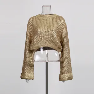 Makroansicht des goldenen Grobstrickmusters und des metallischen Finishs dieses Pullovers