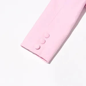 Detailed close-up of three elegant fabric-covered buttons on a pink blazer's sleeve cuff