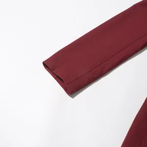 Close-up detail of a burgundy elegant woman blazer sleeve cuff on a white background