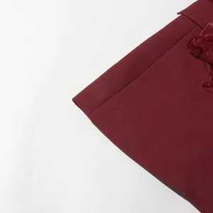 Detailed close-up of burgundy women's blazer with elegant ruffle trim and texture