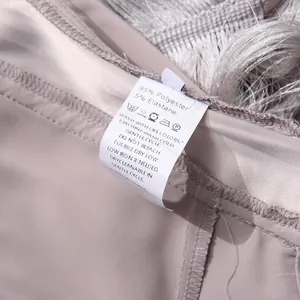 Close-up of care label showing material and washing instructions for the fringe tassel top