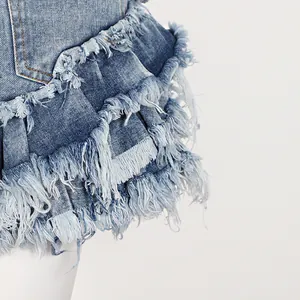 Détail d'un short en jean avec des bords effilochés à plusieurs niveaux et franges.