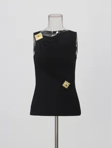 Elegante top negro sin mangas con decoraciones de ojos dorados y detalles plisados refinados