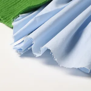 Detail van Franse stijl groene gebreide trui met gerafelde blauwe overhemdstof