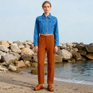 Ganzkörperfoto eines Models in einer kurzen blauen Jeansjacke und einer braunen Stoffhose
