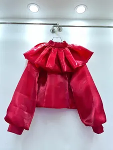 Close-up of glossy red organza blouse with dramatic layered ruffle collar