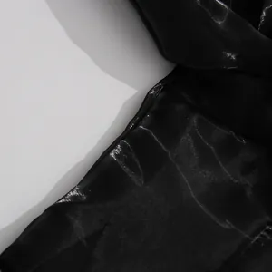 Close-up detail of glossy black satin fabric showing smooth texture and sheen