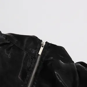 Close-up detail showing the silver metallic zipper on black shiny long-sleeved shirt