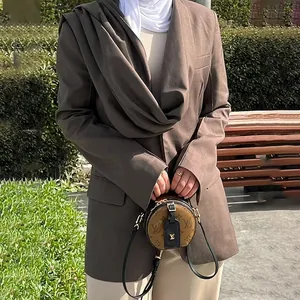 Detalle de una elegante chaqueta americana entallada marrón con efecto chal para mujer
