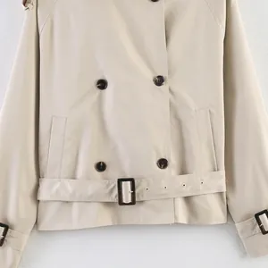 Detail view of a beige British style retro trench coat with buttons and waist belt