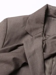 Vista detallada en primer plano de un blazer marrón que muestra la textura y solapa