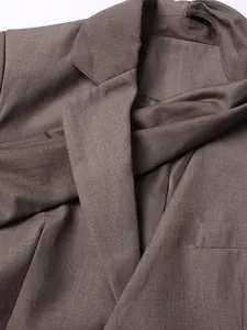 Primer plano del detalle de la solapa y la textura de la tela de un blazer marrón de mujer
