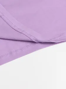Close-up of neat stitching on the hem of a soft purple solid color dress detail