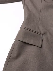 Detalle de primer plano de una chaqueta marrón ajustada con bolsillo de solapa y tejido