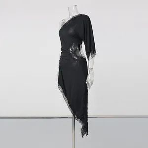 Side view of a black one-shoulder dress featuring intricate lace trim and waist cutout
