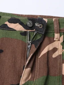 Détail du zip métallique et de la fermeture à bouton sur une jupe en jean camouflage chic